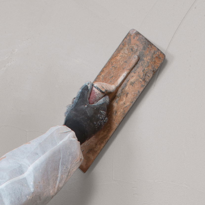 A contractor applied Drybase Renovation Plaster with a trowel.