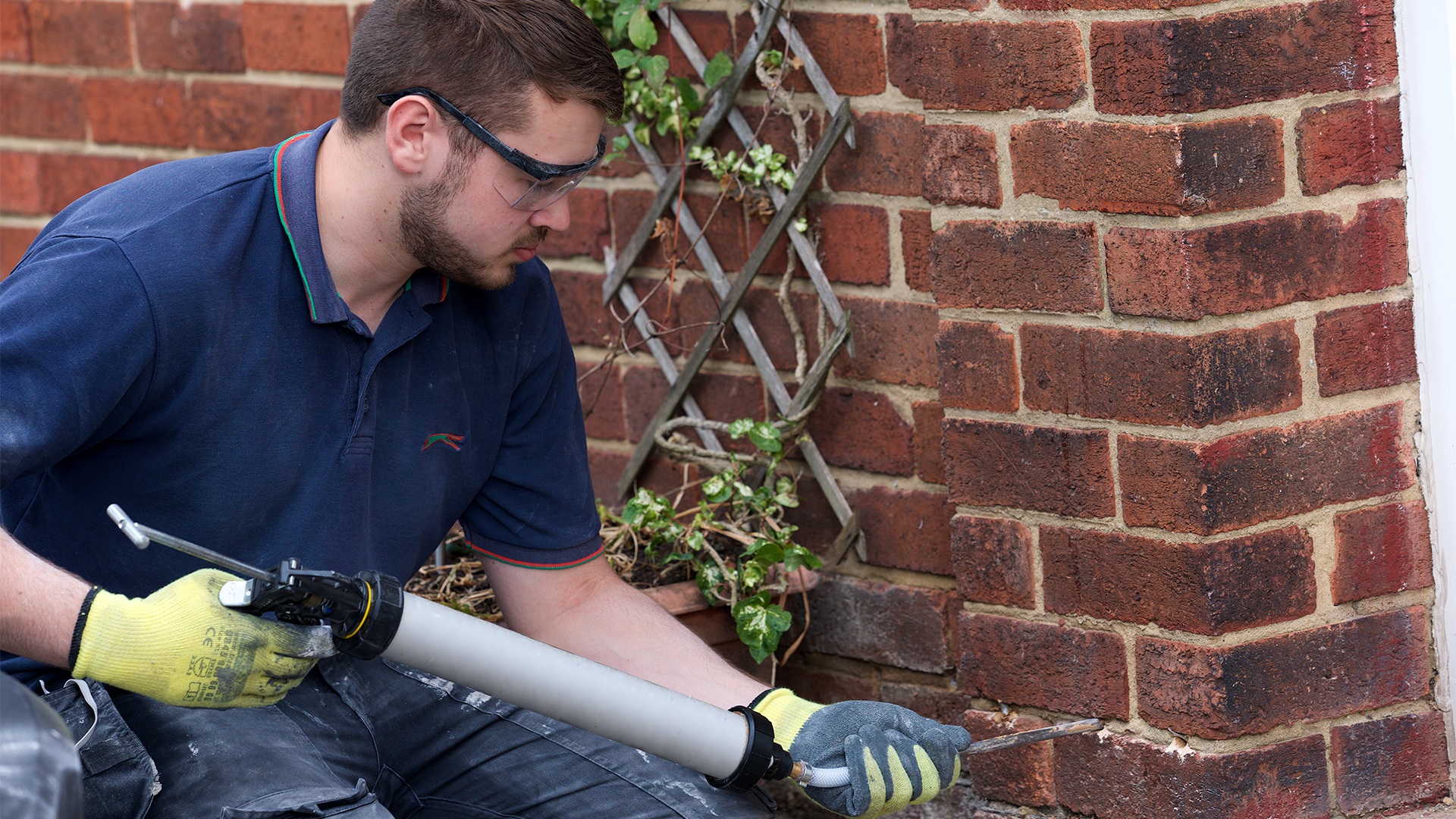 A damp specialist installing a new damp-proof course on an exterior wall.