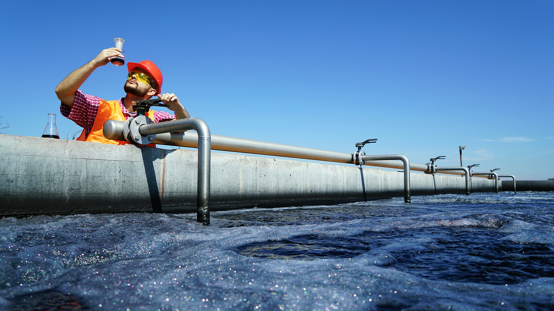 A worker at a water treatment works testing the water.