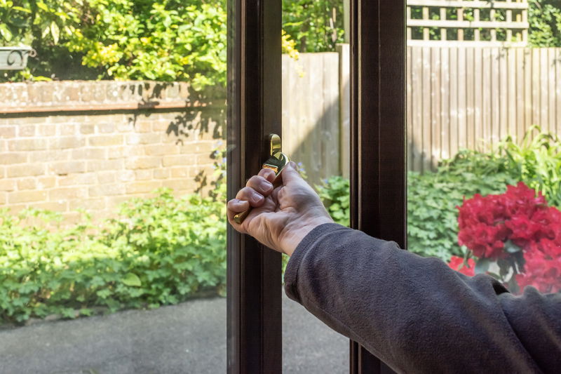 A man opens a glass door for ventilation