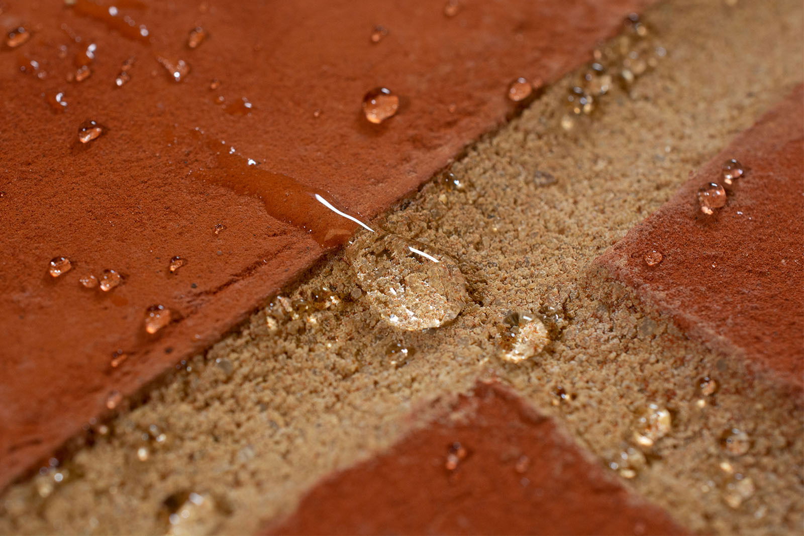 A drop of water beading on brick and mortar.