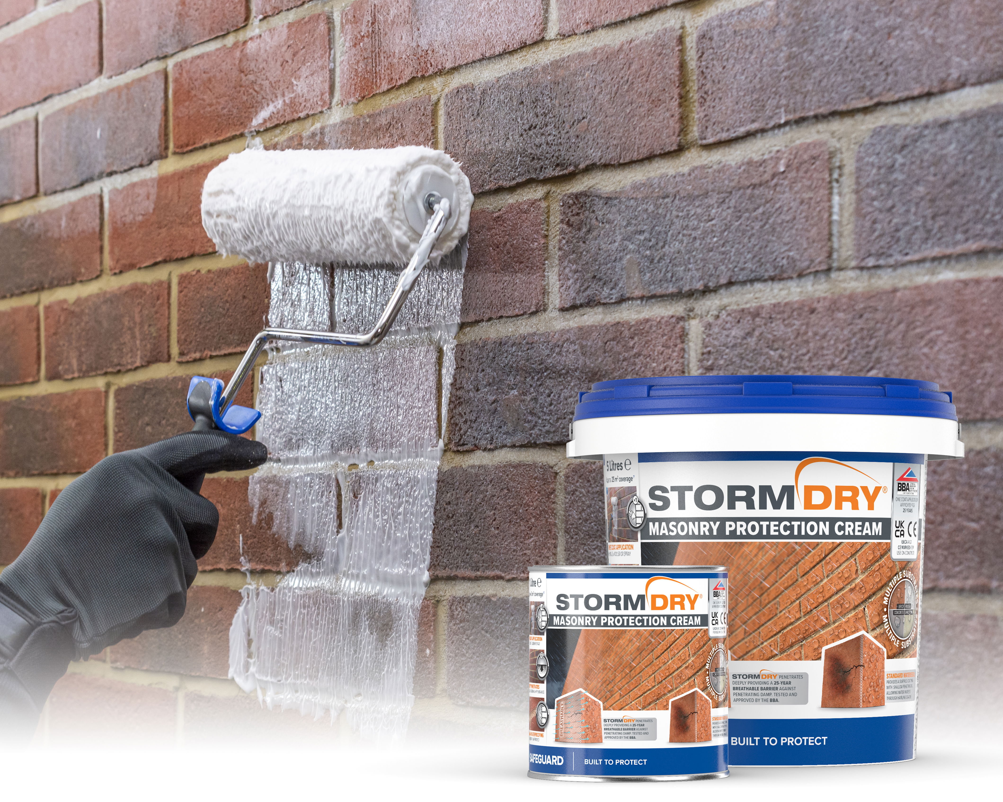 2 Stormdry tubs - 5 and 1 litres. In the background, a roller brushes on Stormdry Masonry Protection Cream.