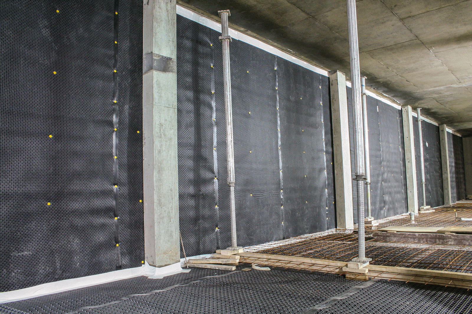 A membrane applied on walls and floor of a basement.