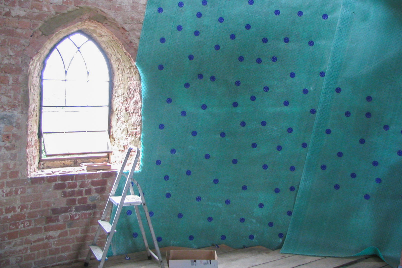 An internal wall covered with a membrane using a ladder.