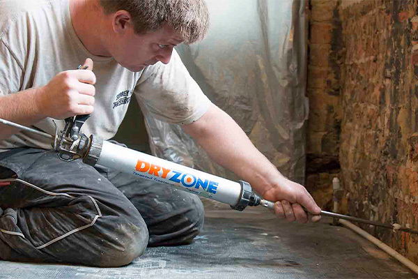 A contractor installs Dryzone DPC Cream on an installed wall.
