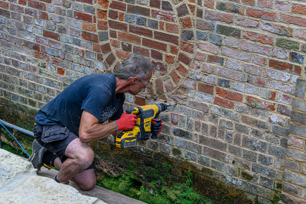 Drilling holes in exterior wall prior to Dryzone DPC Cream installation.