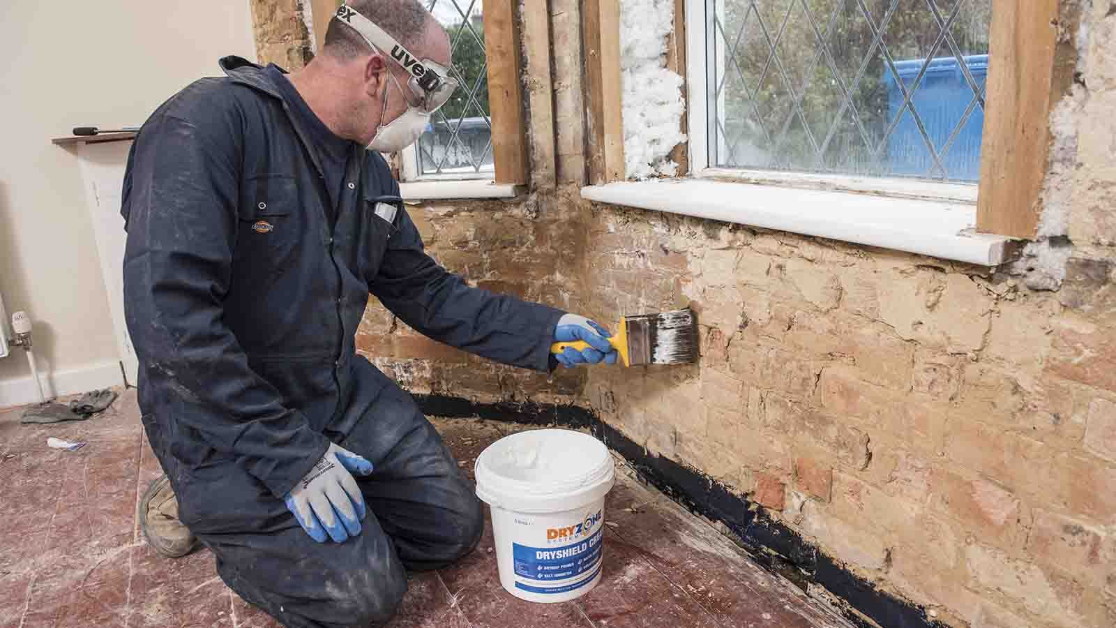 A contractor applying Drygrip Adhesive on to the reverse of the plasterboard.