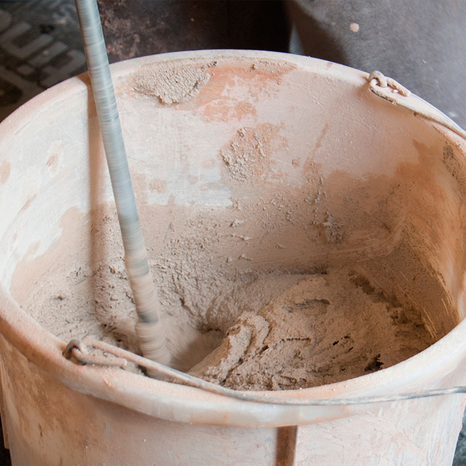 Plaster mixed in a bucket with a paddle mixer.