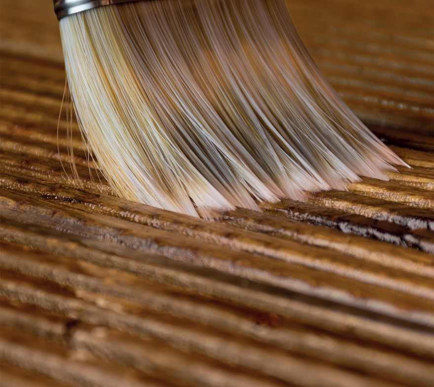 The Roxil Enhanced Decking Oil applied on a deck by brush.