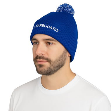 Craig the male model wears a Safeguard Beanie Hat with Bobble in Blue. White background.